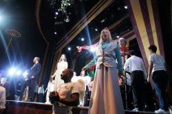 Woman performer on stilts and Norwegian Gem singers dancers on stage Stardust Theater.jpg